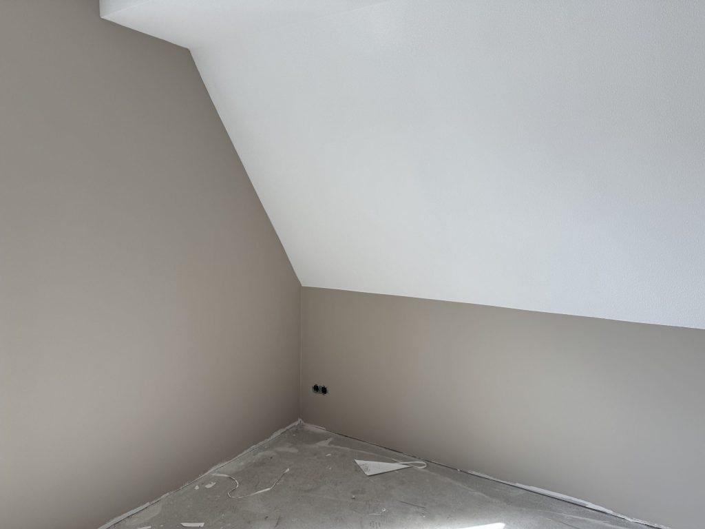 Zolderkamer in een nieuwe eengezinswoning met een schuine wand en strak afgewerkte muren